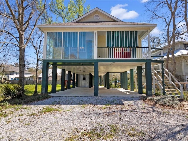 beach home with a carport, driveway, and stairs