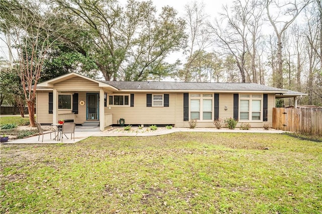 ranch-style house with entry steps, a front lawn, fence, and a patio