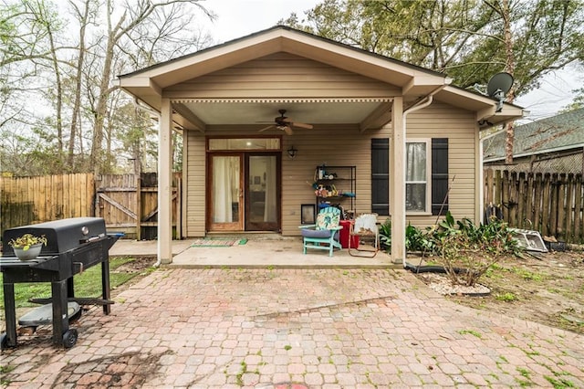 back of property with a ceiling fan, a patio, and fence