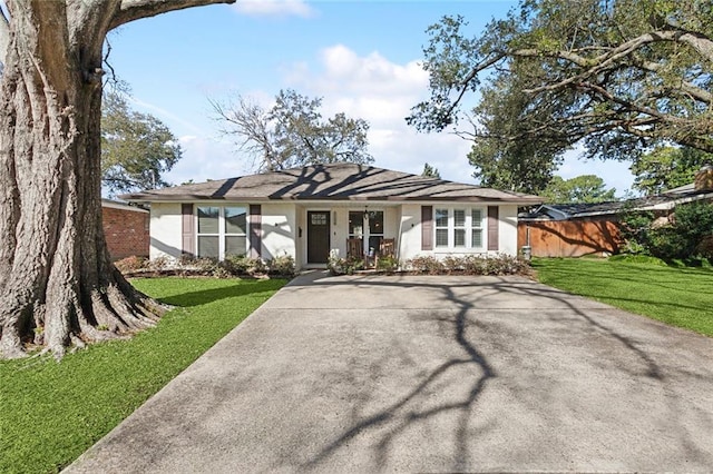 single story home with stucco siding, a front yard, and fence