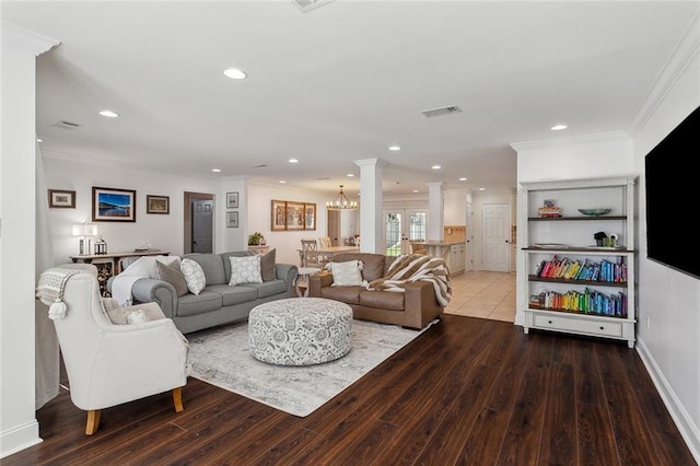 living area with crown molding, ornate columns, and wood finished floors