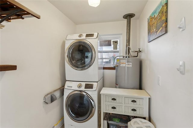 washroom with laundry area, stacked washer / drying machine, and water heater