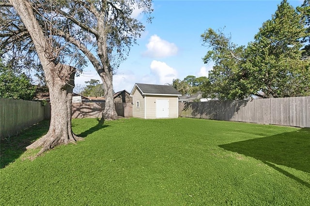 view of yard featuring an outdoor structure, a storage unit, and a fenced backyard