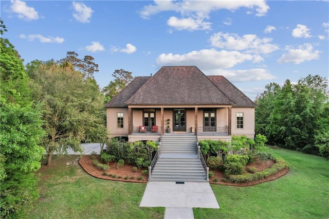 view of front of property featuring stairway, stucco siding, a porch, and a front yard