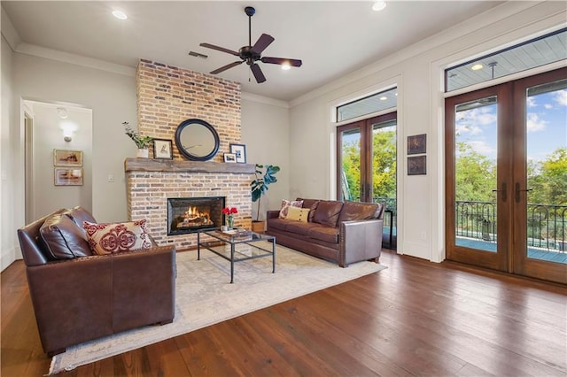 living room with french doors, wood finished floors, visible vents, and ornamental molding