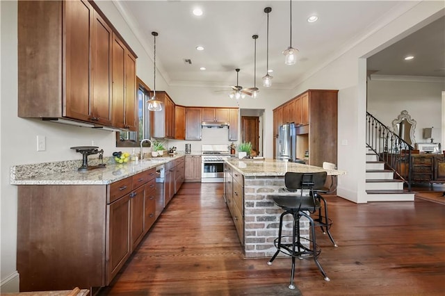 kitchen featuring light stone counters, dark wood finished floors, appliances with stainless steel finishes, and ornamental molding