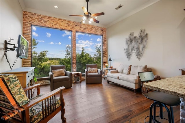 interior space with dark wood-style floors, visible vents, brick wall, ceiling fan, and crown molding