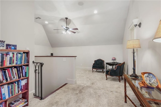 sitting room with lofted ceiling, an upstairs landing, visible vents, and carpet floors