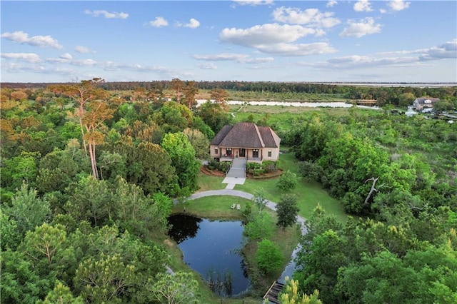 drone / aerial view with a forest view and a water view