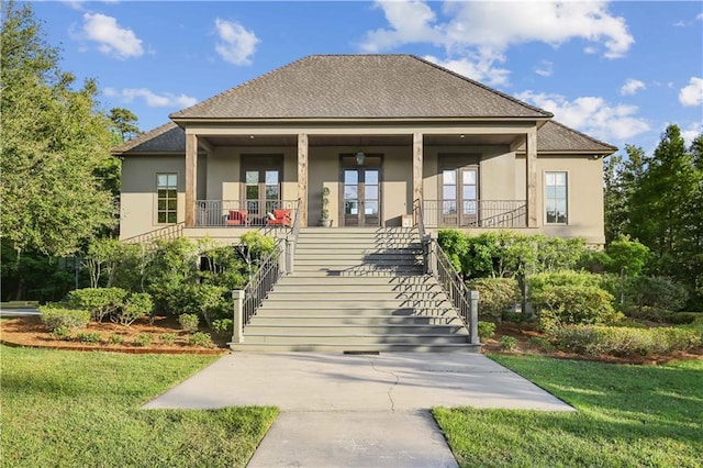 back of house with stucco siding, a yard, a porch, and stairs