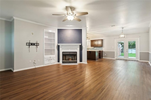 unfurnished living room with baseboards, a fireplace with flush hearth, dark wood-style flooring, and crown molding