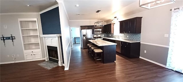 kitchen with a kitchen island, a fireplace with flush hearth, a kitchen bar, light countertops, and stainless steel appliances