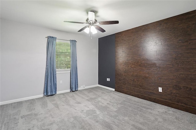 carpeted spare room with baseboards and ceiling fan