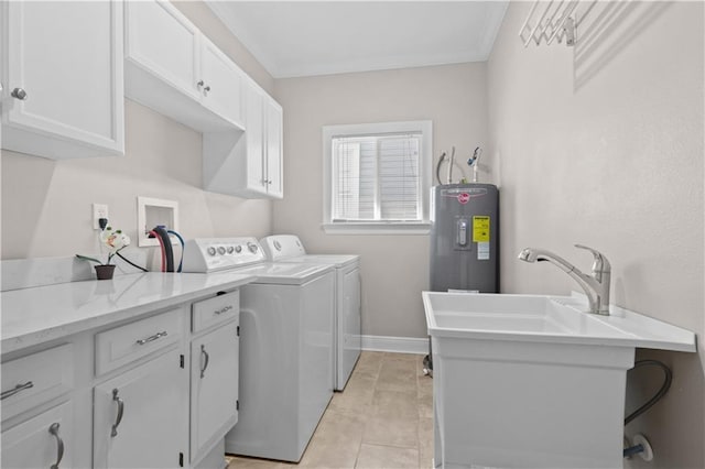 clothes washing area featuring electric water heater, crown molding, washing machine and dryer, cabinet space, and a sink