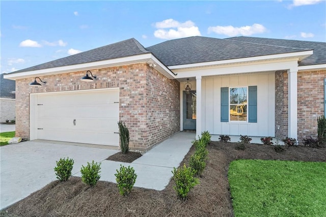 ranch-style house with a shingled roof, concrete driveway, a garage, board and batten siding, and brick siding