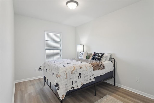 bedroom featuring baseboards and wood finished floors