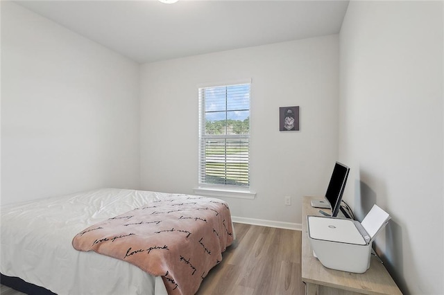 bedroom with baseboards and light wood-style flooring