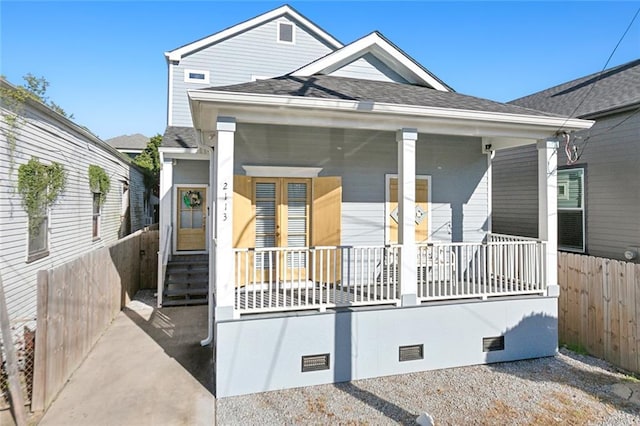 shotgun-style home with crawl space, covered porch, a shingled roof, and fence