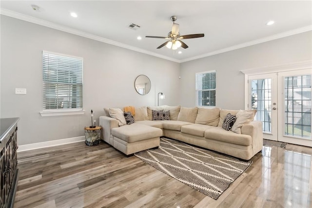 living area featuring ornamental molding, wood finished floors, visible vents, and baseboards