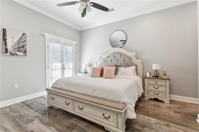 bedroom with visible vents, crown molding, baseboards, and wood finished floors