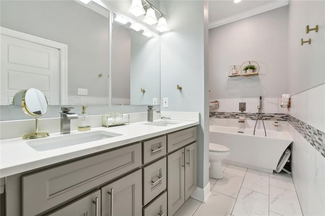 bathroom featuring double vanity, marble finish floor, a freestanding tub, and a sink