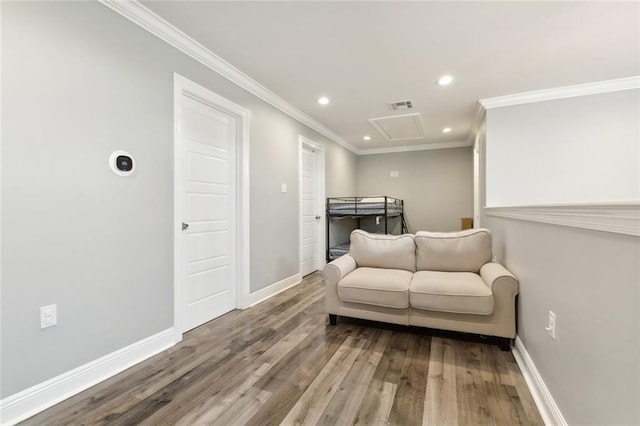 living area with visible vents, attic access, baseboards, and wood finished floors