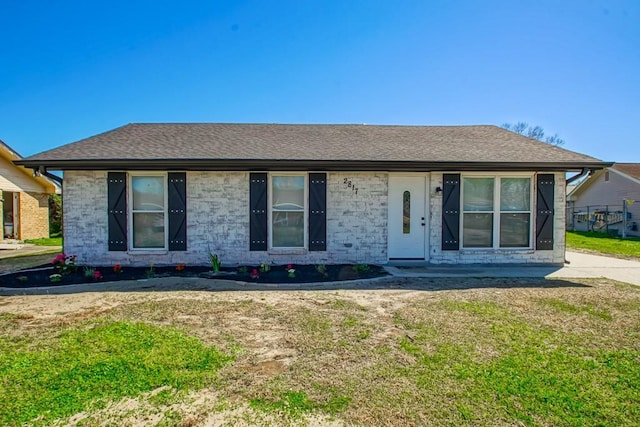 view of front facade featuring a front yard and roof with shingles