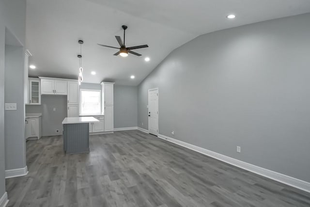 unfurnished living room with baseboards, vaulted ceiling, recessed lighting, wood finished floors, and a ceiling fan