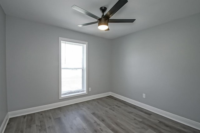 empty room featuring ceiling fan, baseboards, and dark wood-style floors