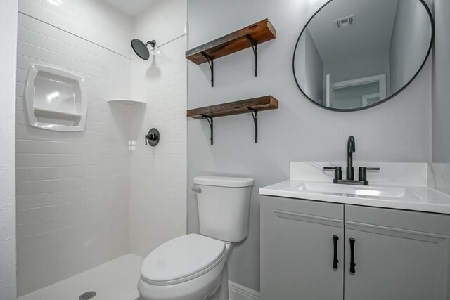 full bathroom featuring visible vents, toilet, vanity, and a tile shower