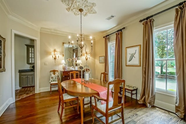 dining space featuring crown molding, wood finished floors, visible vents, and a wealth of natural light