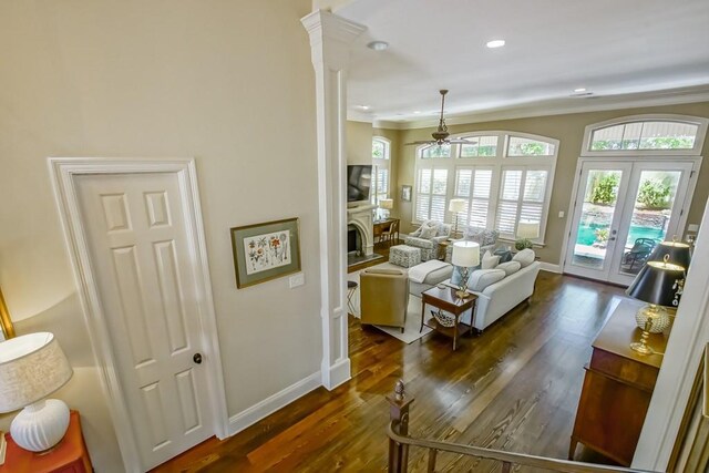 living area with recessed lighting, wood finished floors, baseboards, and ornamental molding