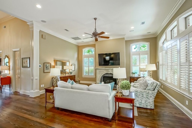 living area with a premium fireplace, a ceiling fan, and ornamental molding
