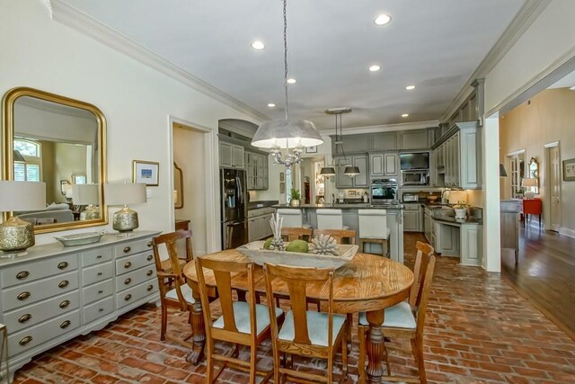 dining space featuring recessed lighting, brick floor, and ornamental molding