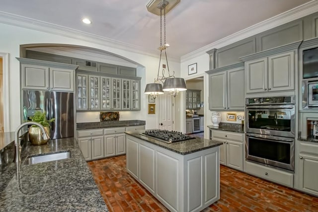 kitchen with a notable chandelier, a sink, a center island, stainless steel appliances, and crown molding