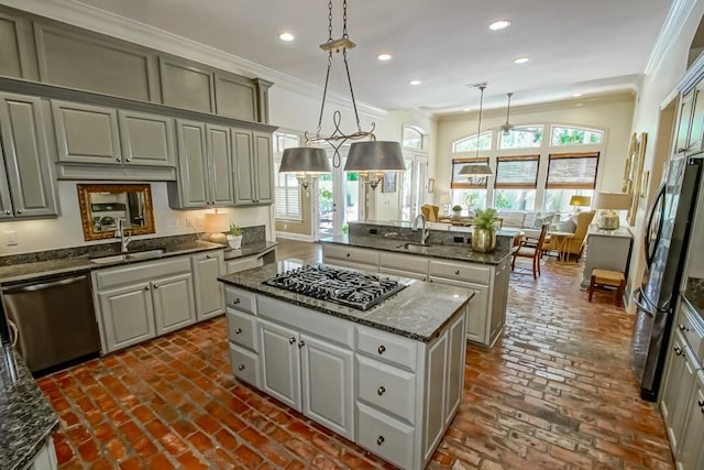 kitchen featuring a sink, ornamental molding, a center island, and stainless steel appliances