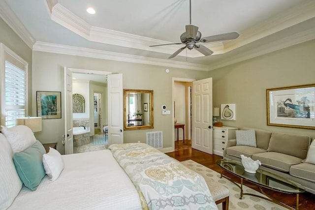 bedroom featuring visible vents, ornamental molding, wood finished floors, a raised ceiling, and a ceiling fan