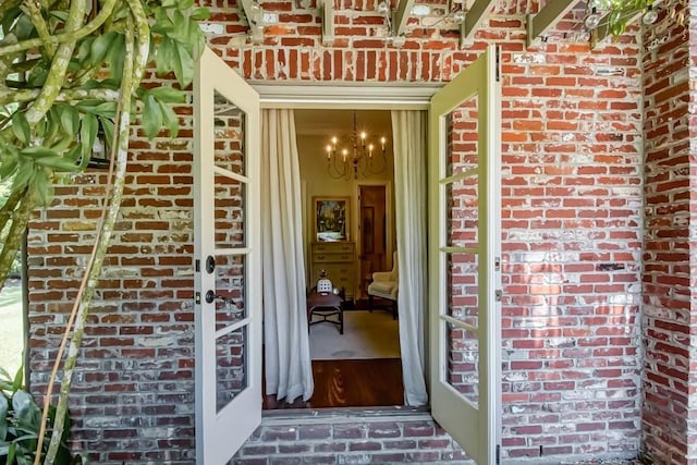 view of exterior entry featuring brick siding