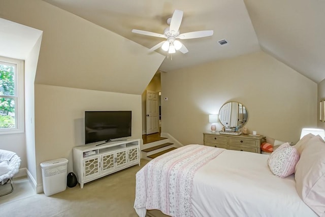 carpeted bedroom with visible vents, lofted ceiling, baseboards, and a ceiling fan