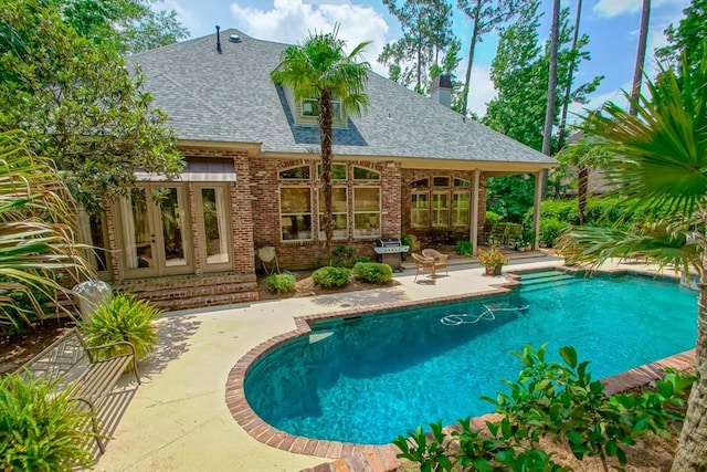 outdoor pool featuring a patio and french doors