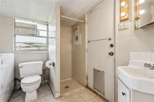 bathroom featuring vanity, tile walls, toilet, and a stall shower