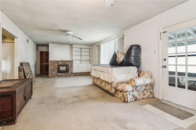 carpeted living area with plenty of natural light, a brick fireplace, and ceiling fan