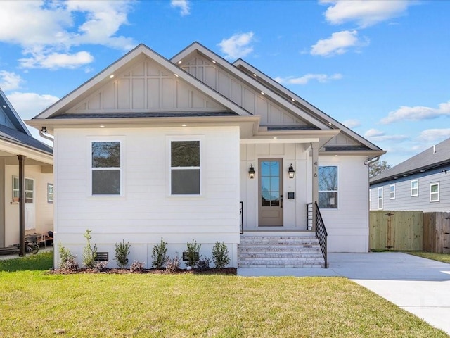 view of front of home featuring crawl space, board and batten siding, a front lawn, and fence