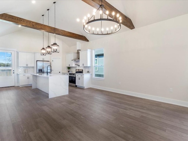 kitchen with beam ceiling, decorative backsplash, light countertops, appliances with stainless steel finishes, and wall chimney range hood