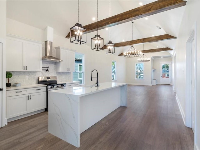 kitchen featuring beam ceiling, dark wood-type flooring, stainless steel range with electric stovetop, tasteful backsplash, and wall chimney exhaust hood