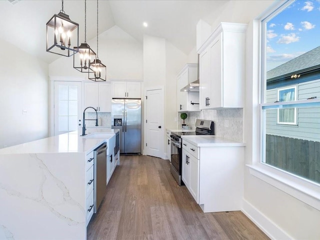 kitchen with wood finished floors, a healthy amount of sunlight, and stainless steel appliances