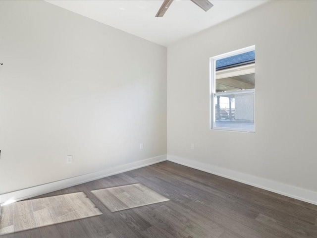 spare room featuring a ceiling fan, wood finished floors, and baseboards