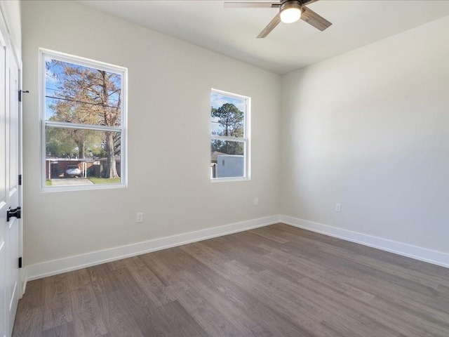 spare room with dark wood finished floors, baseboards, and ceiling fan