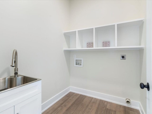 clothes washing area featuring wood finished floors, cabinet space, baseboards, hookup for an electric dryer, and hookup for a washing machine