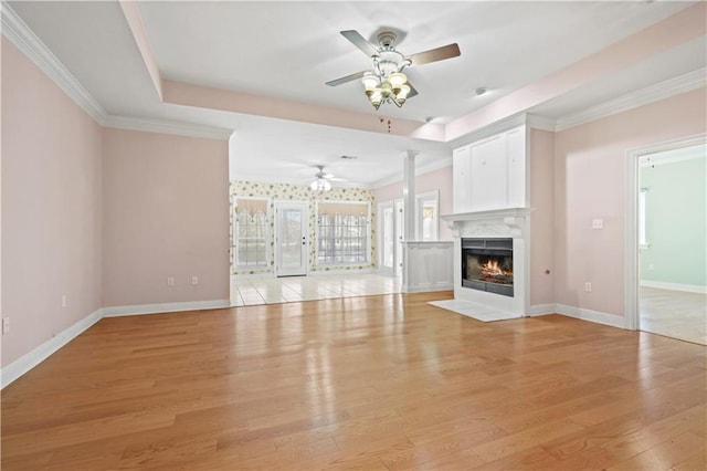 105 Cherokee Dr, Abita Springs, LA 70420 - unfurnished living room featuring a ceiling fan, light wood finished floors, baseboards, a fireplace with flush hearth, and crown molding
